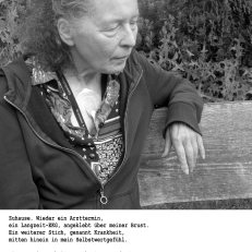 Schwarz-weiß-Fotografie einer älteren Frau mit ernstem Blick, die auf einer Bank sitzt.