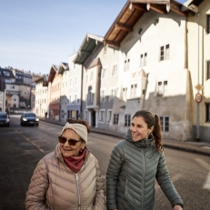 Mutter und Tochter spazieren bei guten Wetter durch die Stadt.