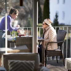 Mutter und Tochter essen auf dem Balkon.