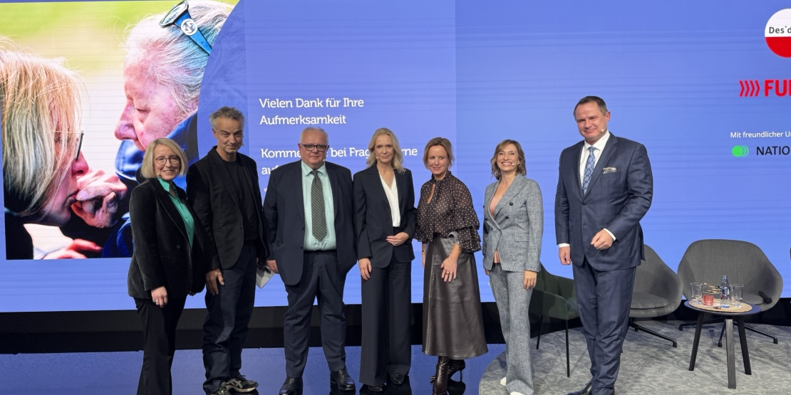Podiumsdiskussion in Essen, Sprecherinnen stehen auf der Bühne vor blauem Hintergrund