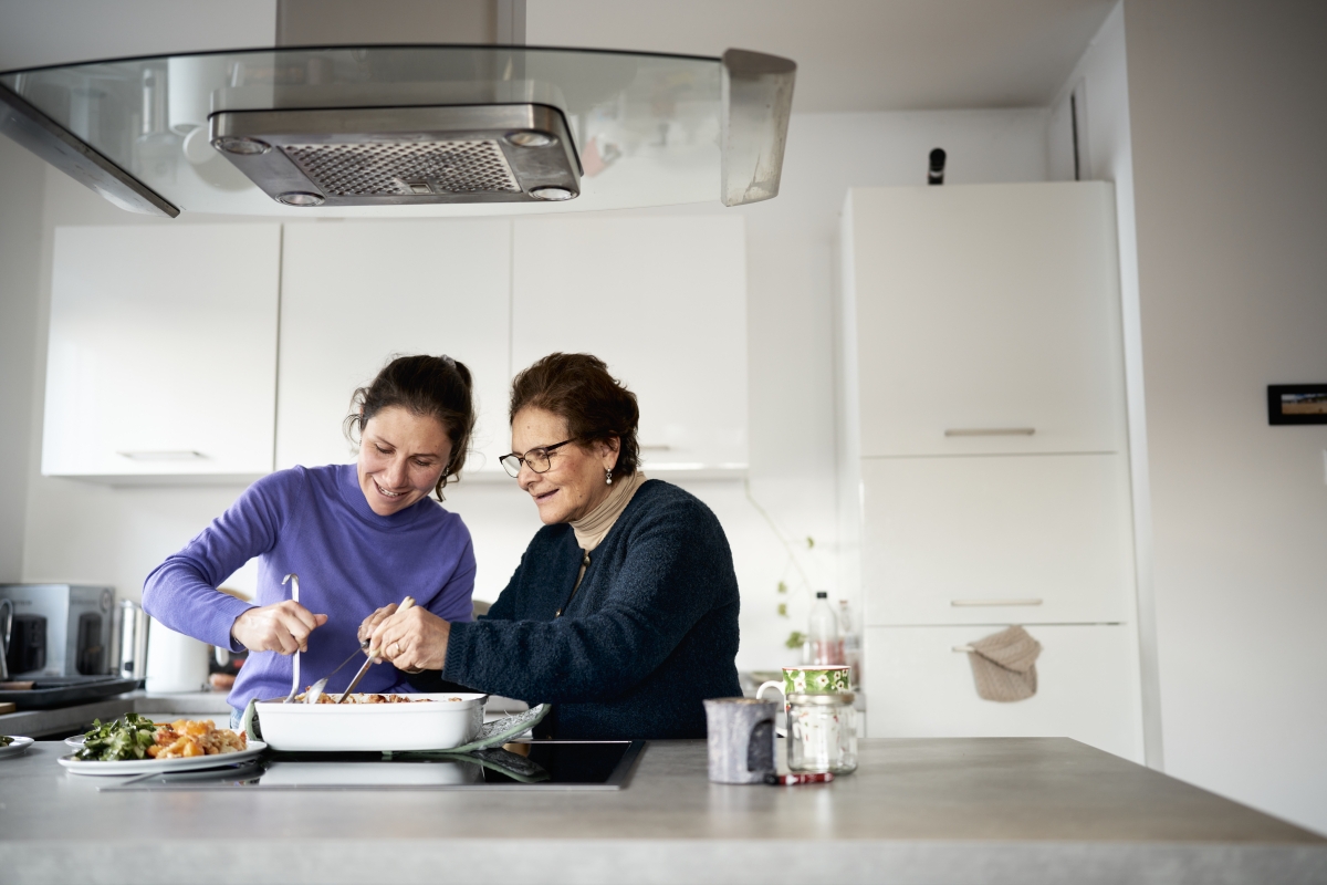 Mutter und Tochter kochen zusammen in der Küche.