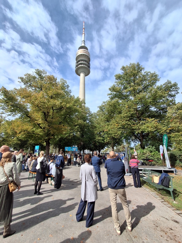 Mneschen stehen vor einer Bühne im Olypmiapark München