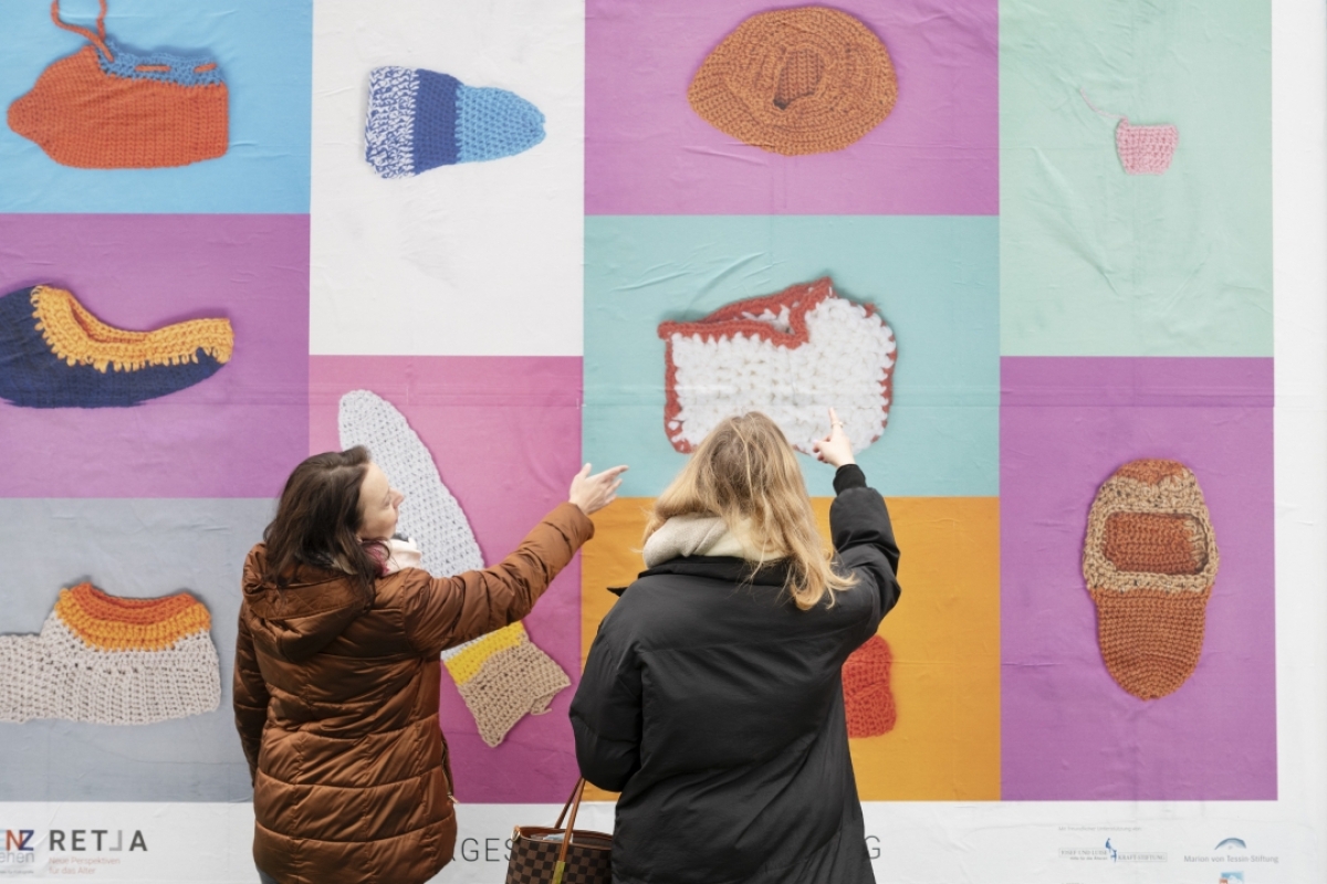 Zwei Frauen vor einem Plakat der unvergesslichen Ausstellung Demenz neu sehen