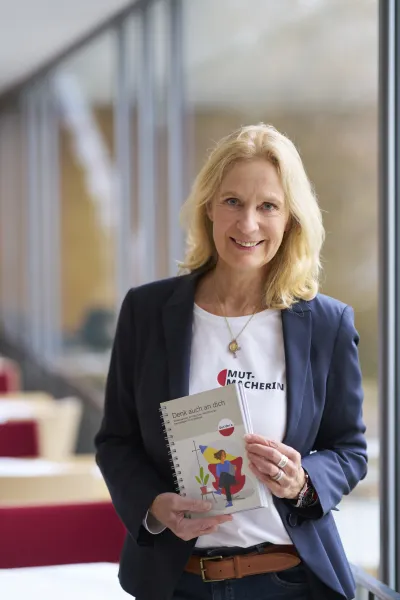Désirée von Bohlen und Halbach mit einem Buch in der Hand Leitfaden für pflegende Angehörige