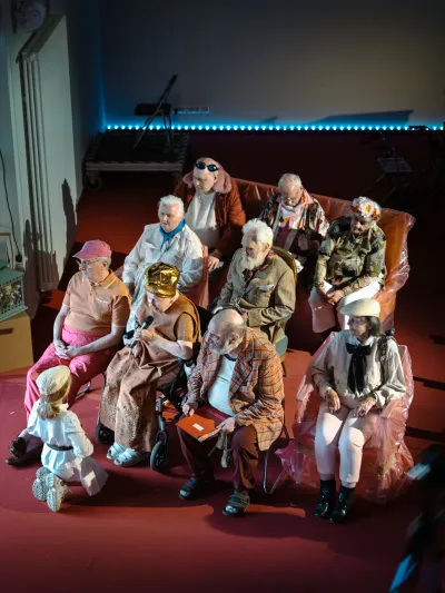 Gruppe älterer Menschen sitzt gemeinsam auf Sofas in einem Raum – Gemeinschaft, Teilhabe und Aktivität im Alter mit Demenz