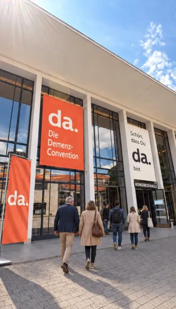 Eingang der alten Kongresshalle München, mit Besuchern und bunten Plakaten der da.