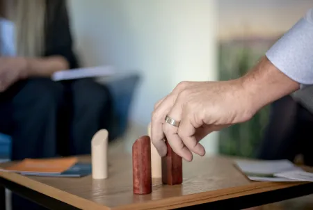 Eine Hand bewegt Holzfiguren auf einem Brett.