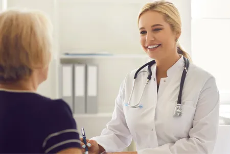 Arztgespräch über Demenz, Frau im Arztkittel