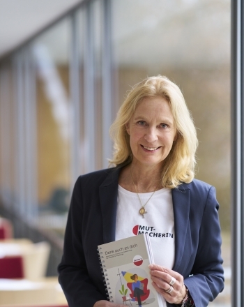 Désirée von Bohlen und Halbach mit einem Buch in der Hand Leitfaden für pflegende Angehörige